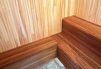 Innenansicht einer Sauna mit hölzernen Sitzbänken und Wänden in einer geräumigen schwedischen Seenvilla.