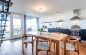 Cocina abierta moderna y comedor en un barco casa con terraza en una casa de vacaciones para 6 personas en Hemmet, Dinamarca.