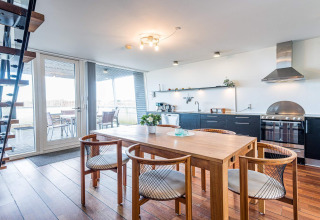Moderne open keuken en eethoek op een woonboot met terras in een 6-persoons vakantiehuis in Hemmet, Denemarken.