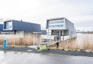 Casa flotante moderna llamada «Casa de vacaciones para 6 personas en Hemmet» sobre el agua en Dinamarca.