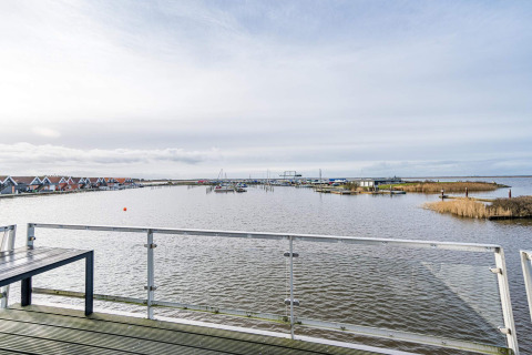 Blick von einem Hausboot in Hemmet, Dänemark, auf das Wasser, Boote und Ferienhäuser im Hintergrund.
