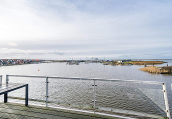 View from a houseboat in Hemmet, Denmark, overlooking the water, boats, railing and holiday homes.
