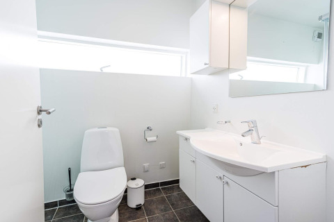 Bagno moderno e luminoso con WC, lavandino, specchio e mobili su una houseboat a Hemmet, Danimarca.