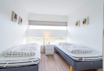 Helles, modernes Schlafzimmer auf einem Hausboot in Hemmet, Dänemark, mit zwei Einzelbetten.