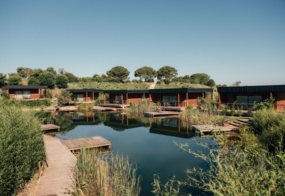 Parque vacacional Wecamp Reserva Alecrim en Alentejo, Portugal, con cabañas modernas junto a un estanque natural.