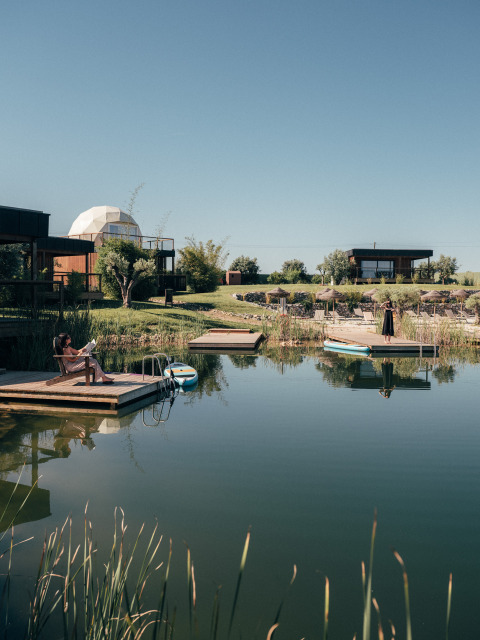 Rustig meer met drijvende steigers en moderne verblijven bij Wecamp Reserva Alecrim in Alentejo, Portugal.