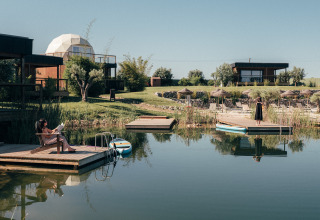 Lac paisible avec pontons et cabanes modernes au Wecamp Reserva Alecrim, Alentejo, Portugal.