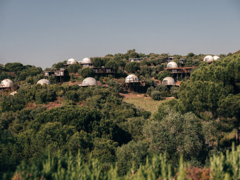 Koepelhuisjes in het Wecamp Reserva Alecrim, te midden van groene heuvels in Alentejo, Portugal.