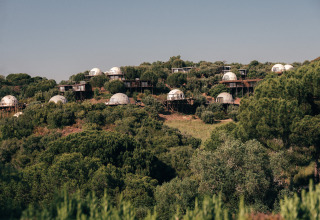 Koepelhuisjes in het Wecamp Reserva Alecrim, te midden van groene heuvels in Alentejo, Portugal.