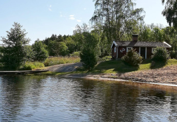 4-Personen-Ferienhaus in NORRTÄLJE, idyllisch am See gelegen, umgeben von grüner Natur.