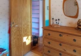 Interieur van een knusse slaapkamer met ladekast, spiegel en gang in een vakantiehuis in Norrtälje, Zweden.
