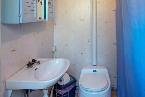 Badkamer met wastafel, toilet en blauwe kast in een 4-persoons vakantiehuis in Norrtälje, Zweden.