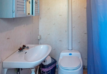 Badkamer met wastafel, toilet en blauwe kast in een 4-persoons vakantiehuis in Norrtälje, Zweden.