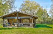 Houten lodge voor 6 personen in Eskebjerg, Denemarken, met groot grasveld en omliggende bomen.