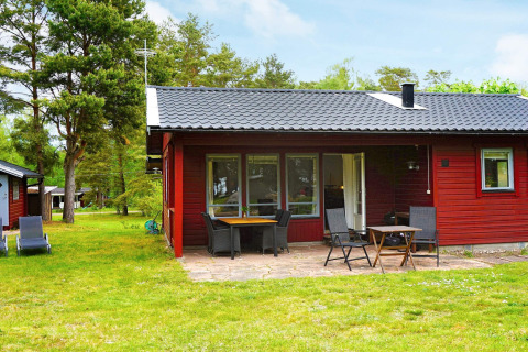 Casa de vacaciones roja para 6 personas en Mönsterås, Suecia, con terraza y muebles de jardín en entorno verde.