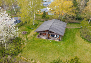 Luchtfoto van een 6-persoons huis in Eskebjerg, Denemarken, omgeven door gras en groene bomen.