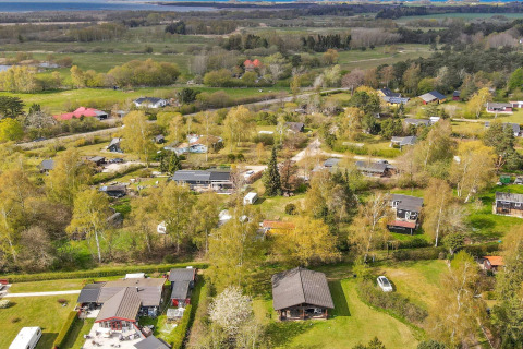 Vista aérea de cabañas, árboles y campos en un entorno verde en Eskebjerg, Dinamarca.