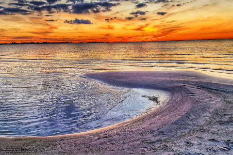 Impresionante puesta de sol en la playa de 6-Person Home en Eskebjerg, Dinamarca, con aguas tranquilas y cielo colorido.