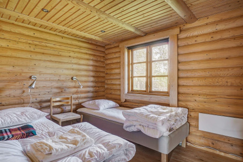 Houten slaapkamer met twee bedden en een raam in een 6-persoons lodge in Eskebjerg, Denemarken.