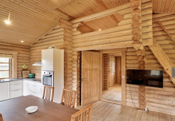 Træhytte i Eskebjerg, Danmark, med moderne køkken, spisebord og TV, lys indretning og åben plan.