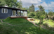 Casa vacacional para 6 personas en Melby, Dinamarca, con terraza de madera y jardín verde en el exterior.