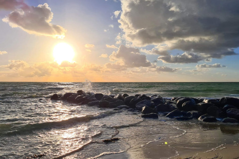 Atardecer sobre el mar con rocas en la orilla, fotografía tomada en una casa de vacaciones en Melby, Dinamarca.