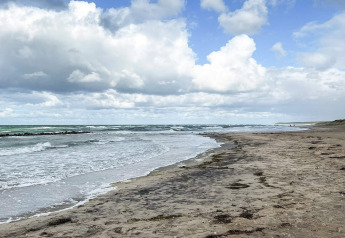 Rustig strand met wolken bij Melby, Denemarken, gezien vanaf een 6-persoons vakantiewoning.