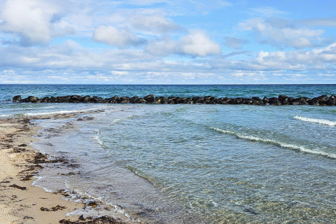 Helder water en rotsen aan het strand bij het vakantiehuis voor 6 personen in Melby, Denemarken.