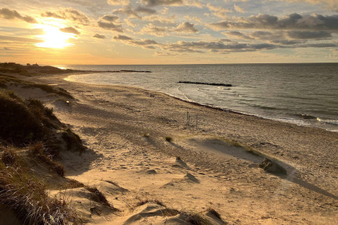 Zonsondergang over een rustige zandstrand in Melby, Denemarken, vanaf de duinen bij het vakantiehuis.