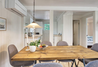 Comedor en casa de vacaciones para 6 personas en Melby, Dinamarca, con mesa de madera y sillas grises.