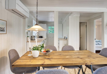Eethoek in vakantiehuis voor 6 personen in Melby, Denemarken, met houten tafel en grijze stoelen.