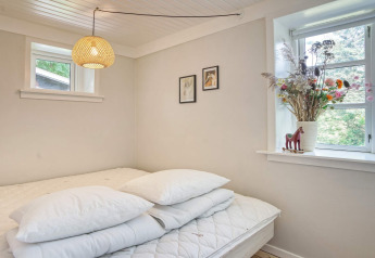 Heldere slaapkamer in 6-persoons vakantiehuis in Melby, Denemarken, met bed, kussen en bloemenvaas.