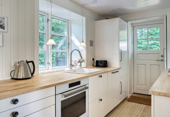 Heldere, moderne keuken in het 6-persoons vakantiehuis in Melby, Denemarken, met houten werkblad.