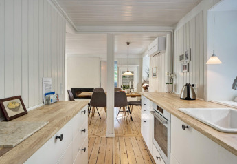 Helles Küche und Essbereich in einem 6-Personen-Ferienhaus in Melby, Dänemark, mit Holzdekor und modernem Stil.
