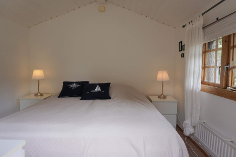 Schlafzimmer mit Doppelbett, zwei Nachttischen und Lampen im 6-Personen-Ferienhaus in Mönsterås, Schweden.