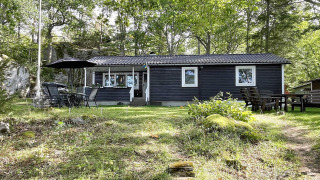 Maison de vacances noire pour 6 personnes à Rimforsa, Suède, entourée d’arbres et coin salon extérieur