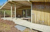 Houten terras bij Seaside Serenity in Snogebaek, Denemarken, met uitzicht op natuur en bosrijke omgeving.