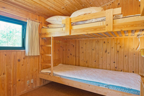 Houten kamer met stapelbedden bij Seaside Serenity in Snogebaek, Denemarken, met natuurlijk daglicht.
