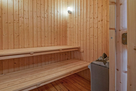 Traditionele houten sauna met banken en stenen kachel in Seaside Serenity in Snogebaek, Denemarken.