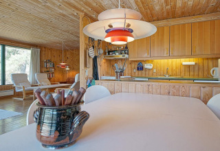 Cocina y salón luminosos con paneles de madera en Seaside Serenity, Snogebaek, Dinamarca.