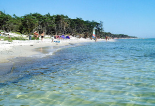 Helder water en strandgangers bij lodge Seaside Serenity in Snogebaek, Denemarken.