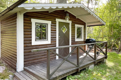 Blockhütte mit Veranda im Wald, Vorderansicht, bei Ferienhaus in Rimforsa, Schweden aufgenommen.