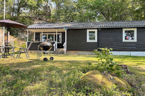 Außenbereich eines 6-Personen-Ferienhauses in Rimforsa, Schweden, mit Grill und Gartenmöbeln.