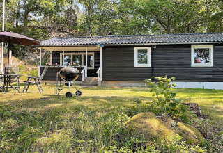 Buitenruimte van 6-persoonsvakantiehuis in Rimforsa, Zweden, met barbecue en tuinmeubilair.