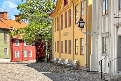 Bunte schwedische Häuser und Kopfsteinpflasterstraße nahe einer Ferienwohnung in Rimforsa, Schweden.