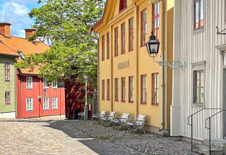 Bunte schwedische Häuser und Kopfsteinpflasterstraße nahe einer Ferienwohnung in Rimforsa, Schweden.