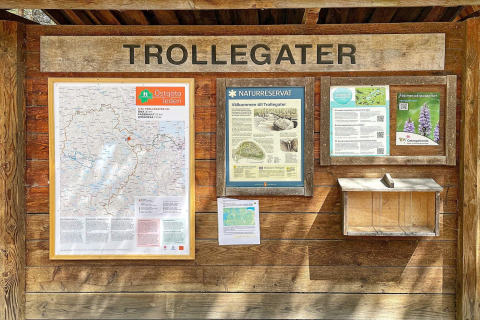 Informatiebord bij het Trollegater natuurreservaat in Zweden, met kaarten, gidsen en details.