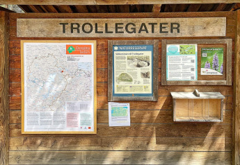 Informationsskilt ved Trollegater naturreservat i Sverige, med kort, naturinfo og lokale guider.