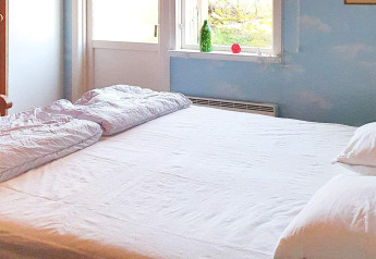 Bright bedroom with double bed, white duvets and pillows, window view, 6 person holiday home in Rimforsa.