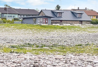 Maison de vacances moderne à Löttorp, Suède, avec fondations en pierre et galets devant la maison.
